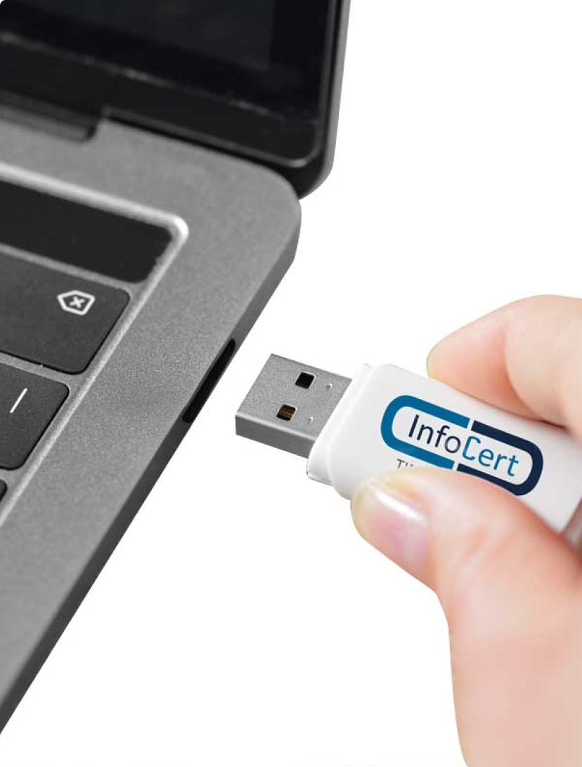 mano con chiavetta business key infocert che viene inserita in un pc